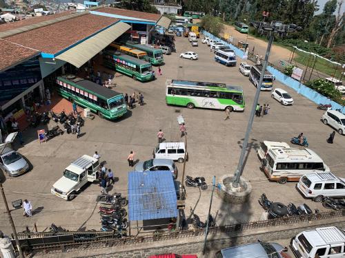 a group of buses and cars parked in a parking lot at JC Woodville Manor in Kodaikānāl