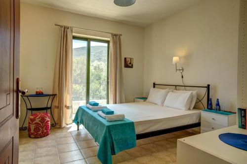 1 dormitorio con cama y ventana grande en SivotaBayVillas Lefkada - 3 bedrooms villas with sea view & private pool, en Sivota