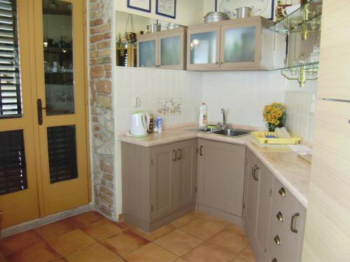 eine Küche mit weißen Schränken und einem Waschbecken in der Unterkunft Anthea Rooms in Split