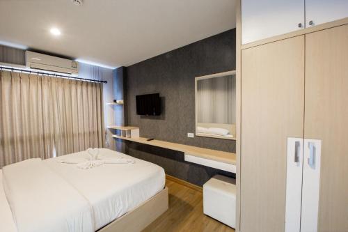 a bedroom with a white bed and a tv at Aonang Ocean View Studio ( The Sea Condo ) in Ao Nang Beach