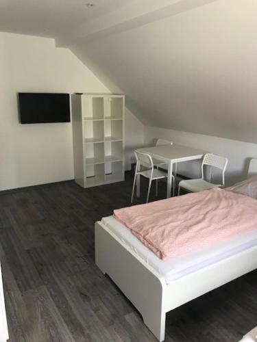 Schlafzimmer mit einem Bett und einem Tisch mit Stühlen in der Unterkunft Oftersheim am Wald Kick Apartment in Oftersheim