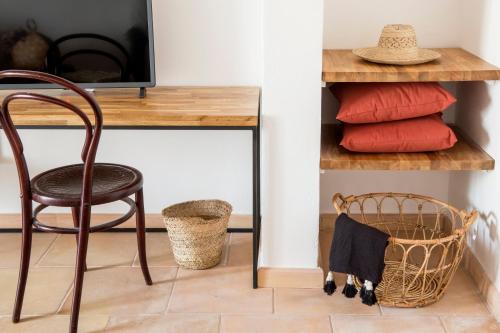 a chair sitting next to a desk with a television at Curolla Petit Hotel in Maria de la Salut