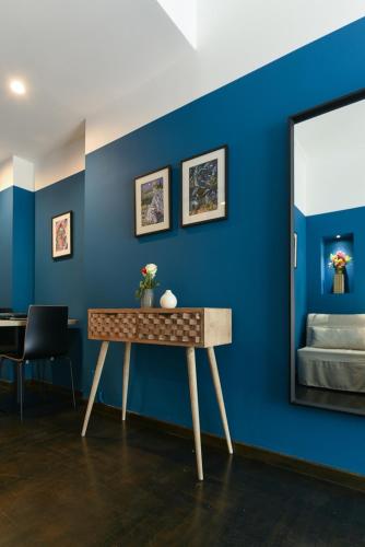 a blue room with a table and a mirror at ATHENS STORIES in Athens