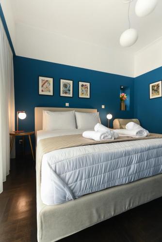 a bedroom with a large bed with a blue wall at ATHENS STORIES in Athens