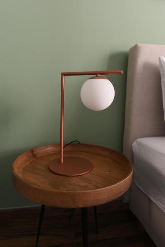 a wooden table with a lamp on it next to a bed at ATHENS STORIES in Athens