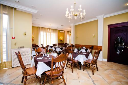 a dining room with tables and chairs and a chandelier at City Club in Kharkiv