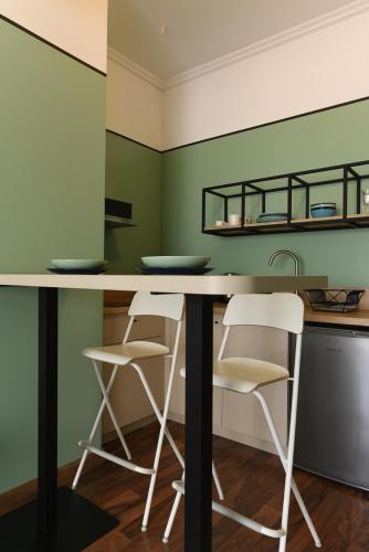 a kitchen with two white chairs and a counter at ATHENS STORIES in Athens