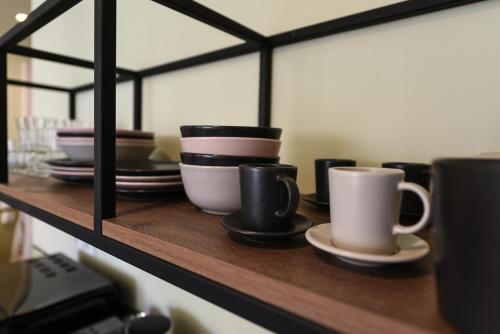 a shelf with plates and coffee cups on it at ATHENS STORIES in Athens