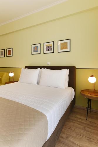 a bedroom with a large white bed with two lamps at ATHENS STORIES in Athens