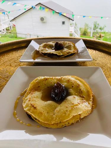 two plates of pancakes with chocolate on a table at Dream Tricule in Sviniţa