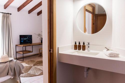 a bathroom with a sink and a mirror at Curolla Petit Hotel in Maria de la Salut