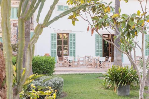 a house with a garden with tables and chairs at Curolla Petit Hotel in Maria de la Salut