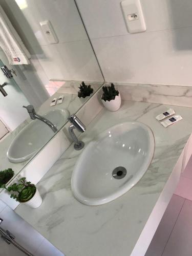 a white bathroom with a sink and a mirror at POUSADA LUNARA in Jequié