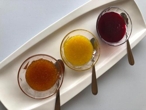 three different colored soups on a plate with spoons at Hotel Boutique La Ceiba in Quimbaya