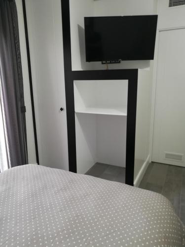 a bedroom with a bed and a flat screen tv at Apartamentos Las Palmeras in Palma del Río