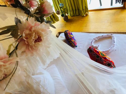 a white dress with a pair of shoes and flowers at Dream Tricule in Sviniţa