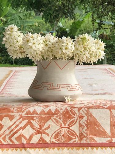 a vase filled with white flowers sitting on a table at Hotel Boutique La Ceiba in Quimbaya