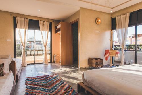 a bedroom with two beds and a large window at The Yogi Surfer in Taghazout