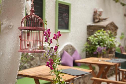 a bird cage hanging from a table with flowers at Gioma Hotel in Agia Galini