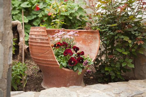 a planter with flowers in it in a garden at Gioma Hotel in Agia Galini