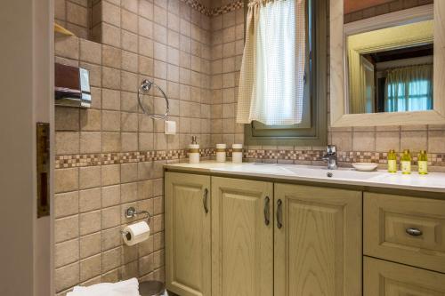 a bathroom with a sink and a mirror at Elaia Villas in Pythagoreio