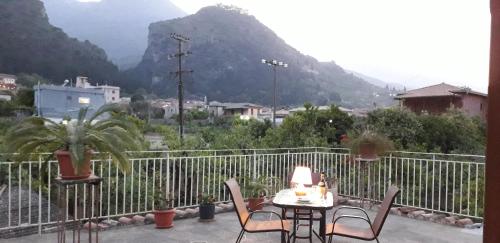 a table and chairs on a balcony with a view of a mountain at Art Flowers and Culture in Mystras