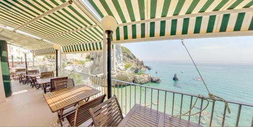 a balcony with tables and chairs and a view of the ocean at Hotel Bellavista in Ponza