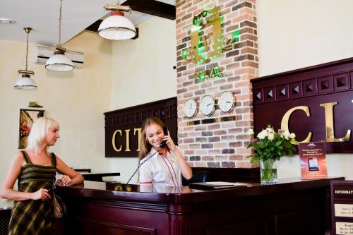 two women standing at a counter talking on a cell phone at City Club in Kharkiv