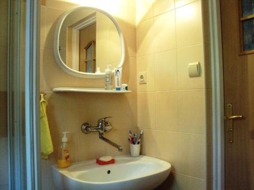 a bathroom with a sink and a mirror at Domek Ostróda in Ostróda