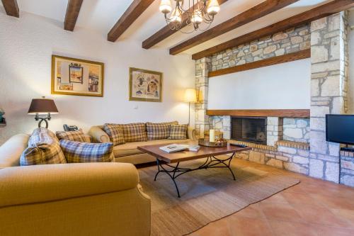 a living room with couches and a stone fireplace at Elaia Villas in Pythagoreio