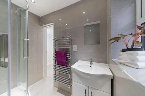 ein Bad mit einem Waschbecken und einer Dusche in der Unterkunft Childs Hill Vacation Home in London