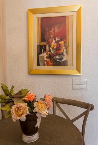 a vase of flowers on a table with a painting at Elaia Villas in Pythagoreio