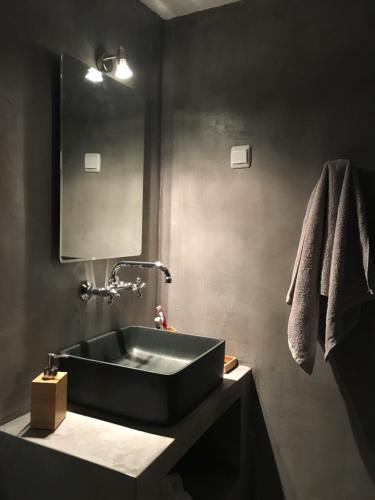 a bathroom with a black sink and a mirror at Traditional Village House in Tílisos