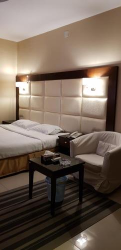 阿爾卡的住宿－Nozul Al Tout Furnished Apartments，酒店客房配有一张床和一张茶几