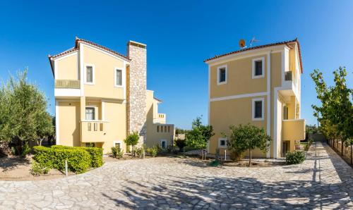 two buildings next to each other on a cobblestone street at Elaia Villas in Pythagoreio