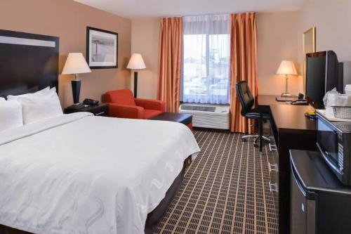 a hotel room with a white bed and a desk and a room with a bed at Hotel Nova SFO in South San Francisco