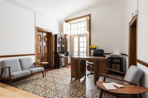 a living room with a couch and a desk at Burgos Guest House in Évora