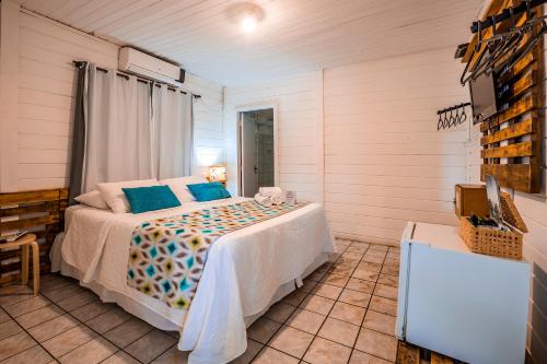 um quarto com uma cama com almofadas azuis em EcoCharme Pousada Arquipélago em Fernando de Noronha