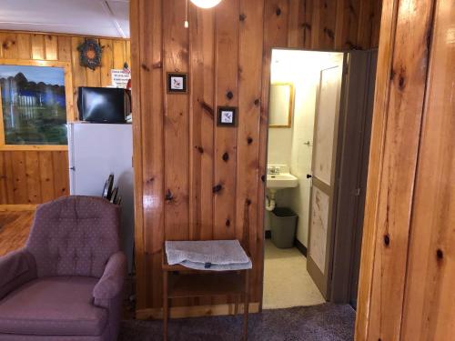 a living room with a chair and a refrigerator at Black Hills Cabins at Quail's Crossing in Hill City