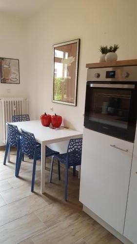 uma cozinha com uma mesa branca com duas taças vermelhas em Königstor em Kassel