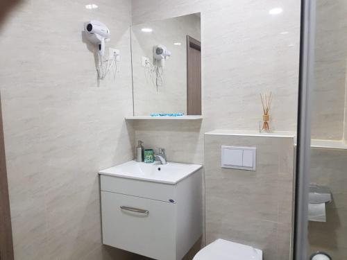ein Badezimmer mit einem WC, einem Waschbecken und einem Spiegel in der Unterkunft Apartament Noblesse, complex Apolonia-Eforie Nord in Eforie Nord