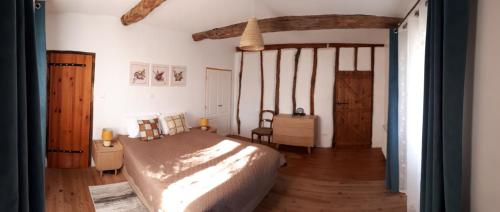 - une chambre avec un grand lit et du parquet dans l'établissement Jazz et Vacances, à Monlezun