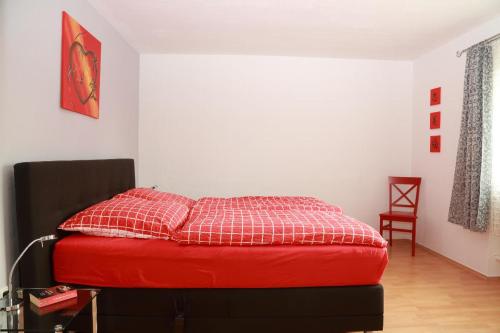 a bedroom with a red bed with a red comforter at Ferienwohnung Casa MIA in Spiegelau