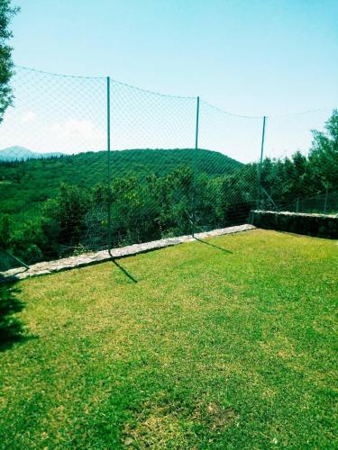 a fence in a field with a mountain in the background at Il Suo Paradiso in Dhavgáta