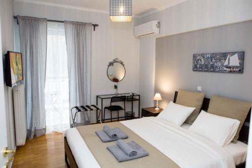 sypialnia z dużym białym łóżkiem z ręcznikami w obiekcie Athens Galatsi Spacious Modern Apartment w Atenach