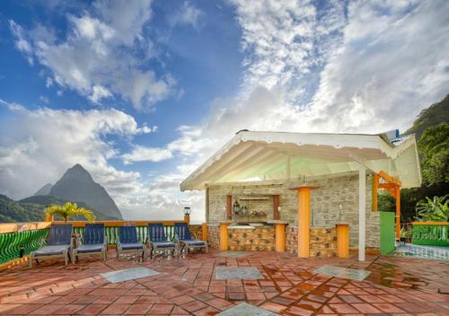 a patio with chairs and a view of a mountain at Villa Des Pitons in Soufrière