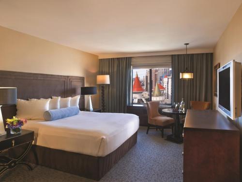 a hotel room with a large bed and a desk at Excalibur in Las Vegas