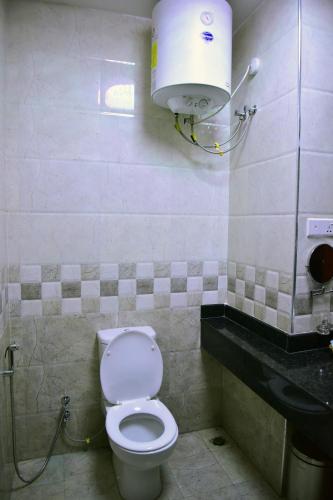 a bathroom with a toilet and a water tank at Hotel Blue Sapphire in Dar es Salaam