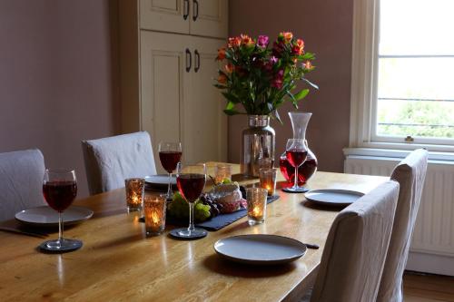 a table with wine glasses and a vase of flowers at Southcot Place, Apartment With Garden in Bath