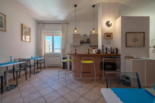 a kitchen and dining room with tables and chairs at NG Guest House l'Acquedotto in Olbia